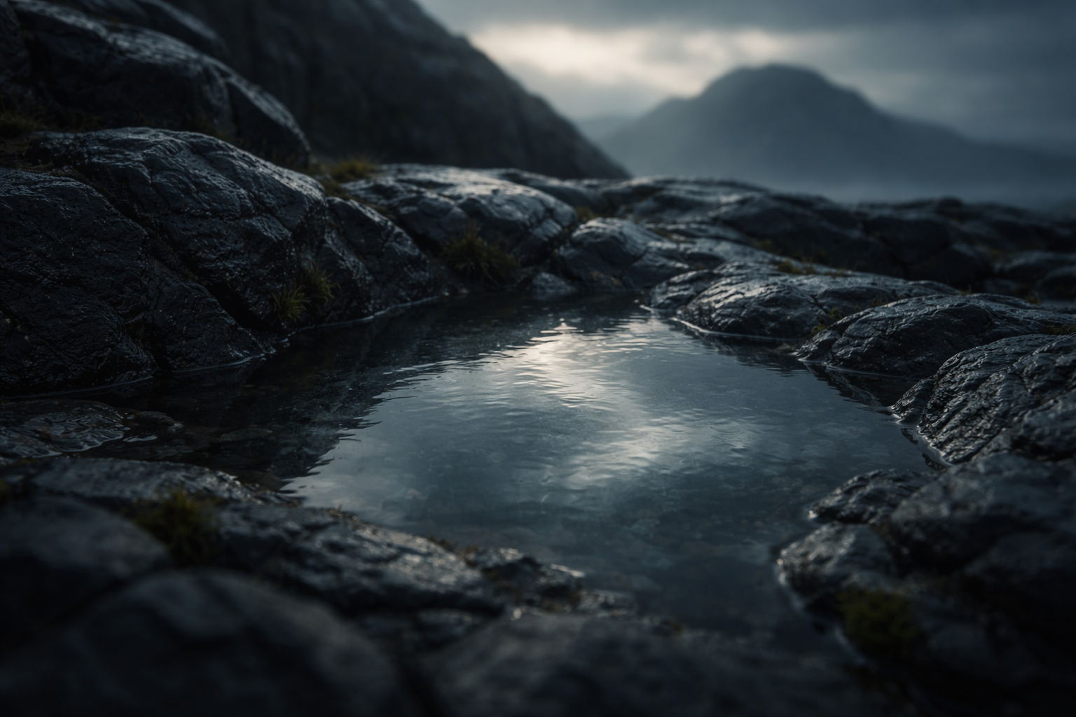 Close-up of a shallow rain pool on dark volcanic basalt reflecting a muted Icelandic sky and the faint silhouette of a low mountain, with wet stone texture in soft dawn light; the reflection occupies the upper two thirds and the bottom of the frame is calm and uncluttered.